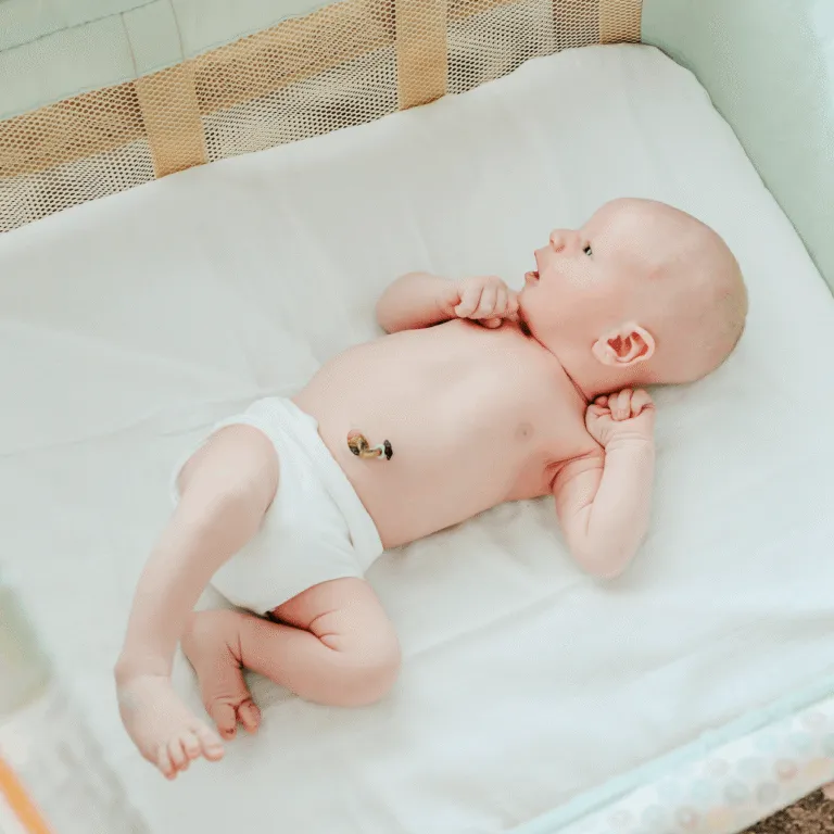 Newborn lying on a changing mat, showing the healing umbilical cord stump
